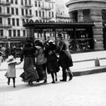 Pedestrians cross the street in the early 1900s